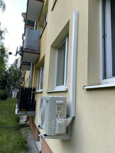Jednostka zewnętrzna klimatyzacji zamontowana przy budynku – realizacja 99